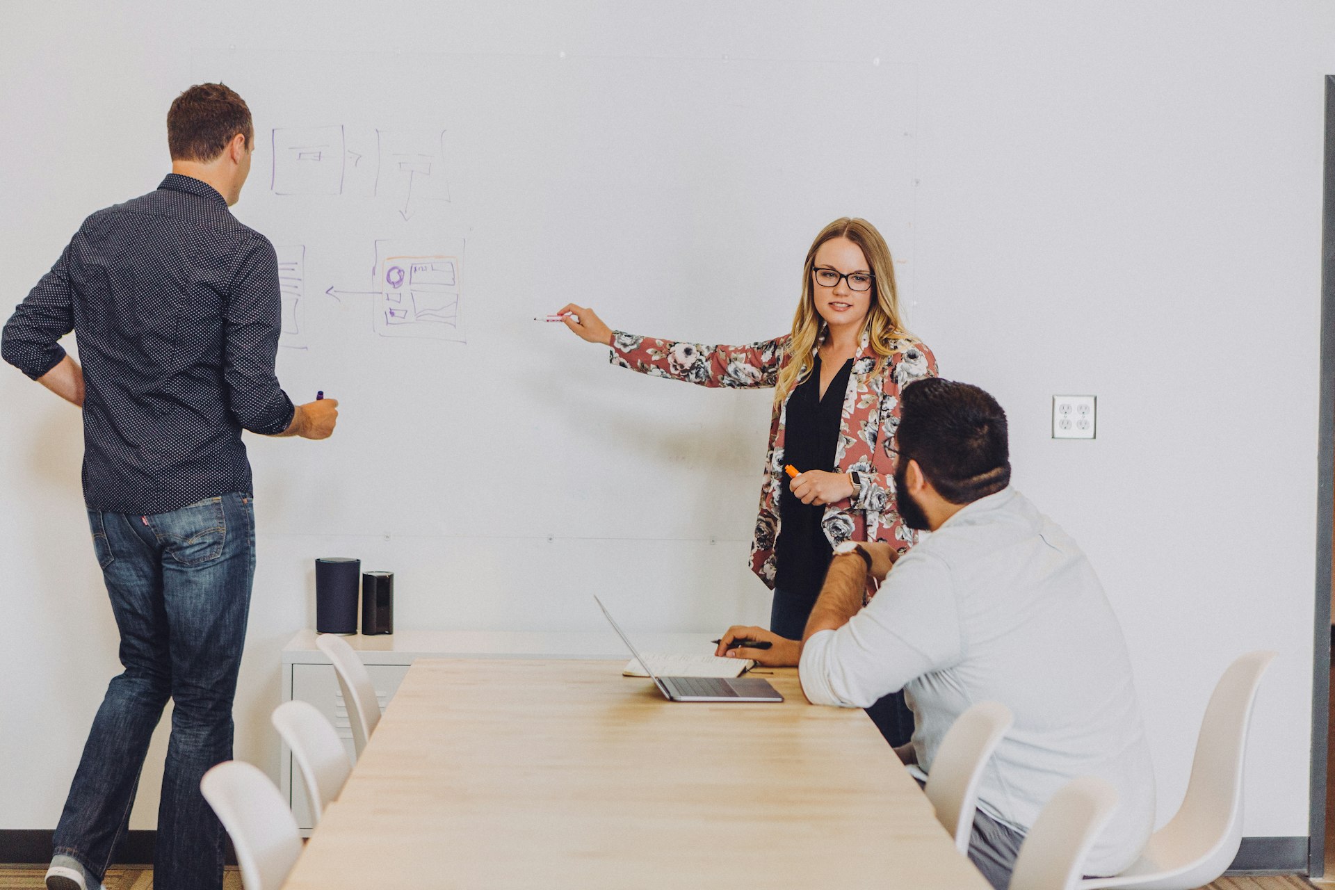 A team sketching out a strategy and wireframes together on a whiteboard